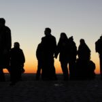 Other people's silhouette against sunset